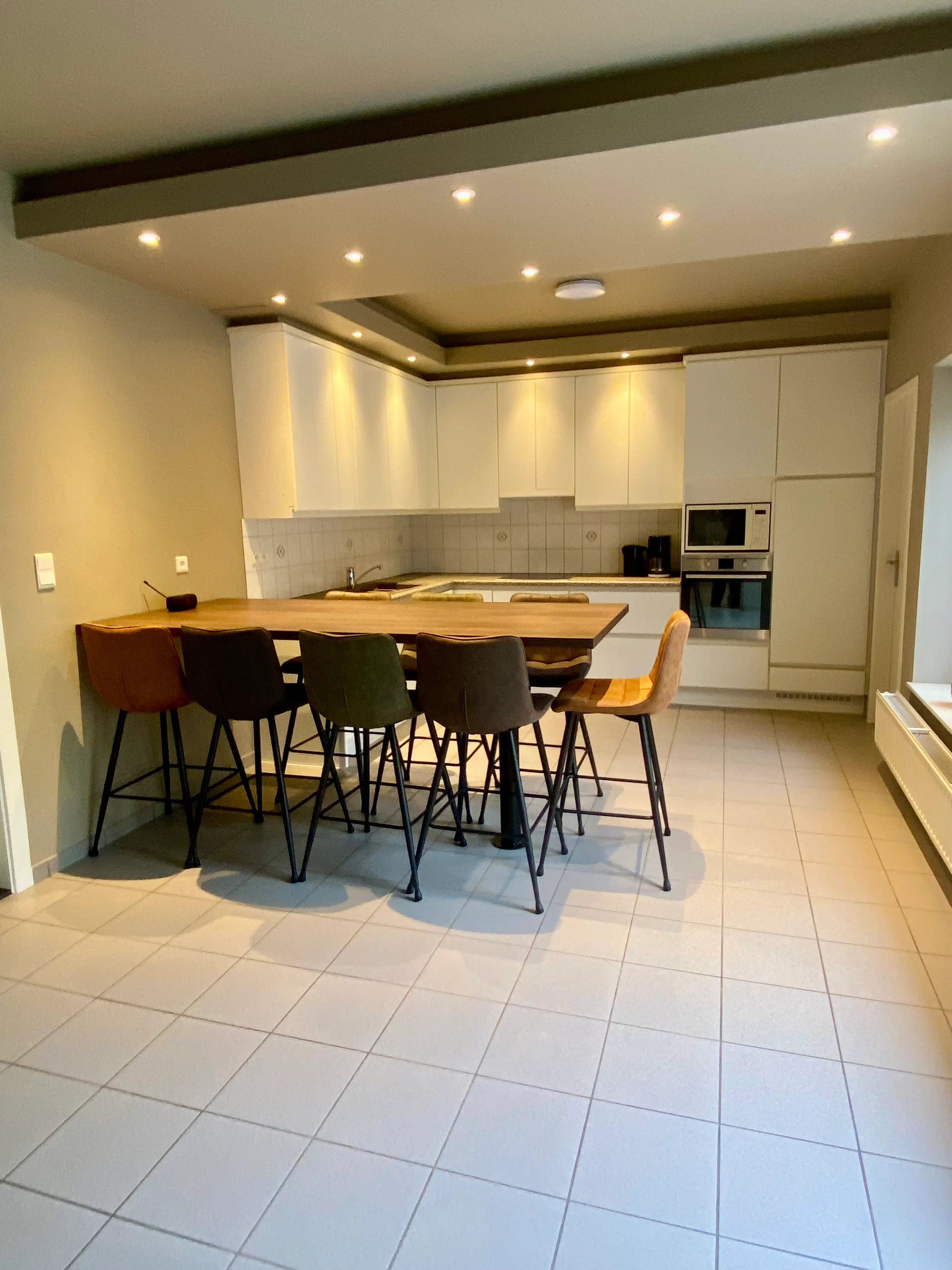De keuken met een houten tafel en zes krukken