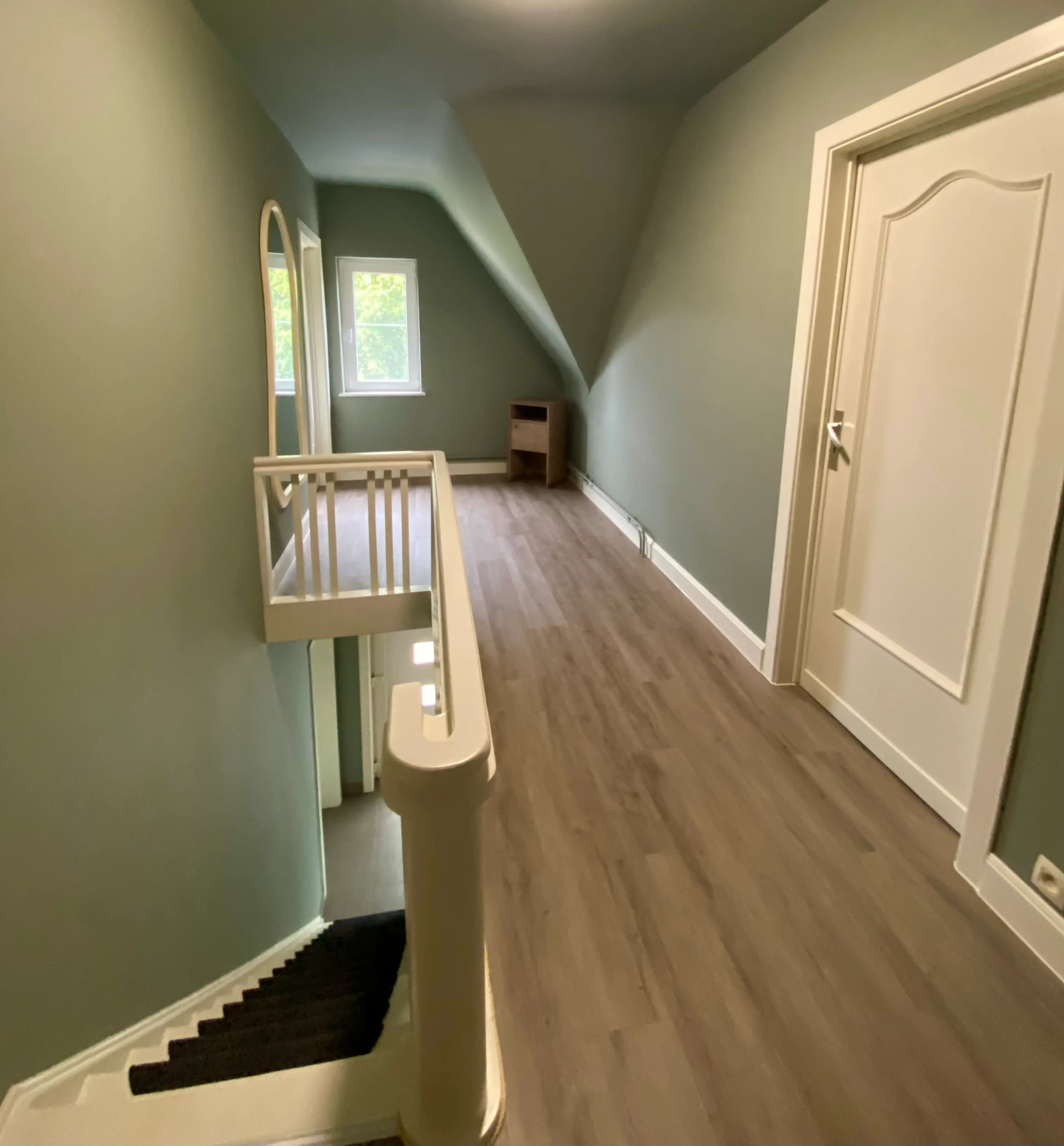 De overloop op de verdieping, met de trap naar beneden en de deuren naar de slaapkamers
